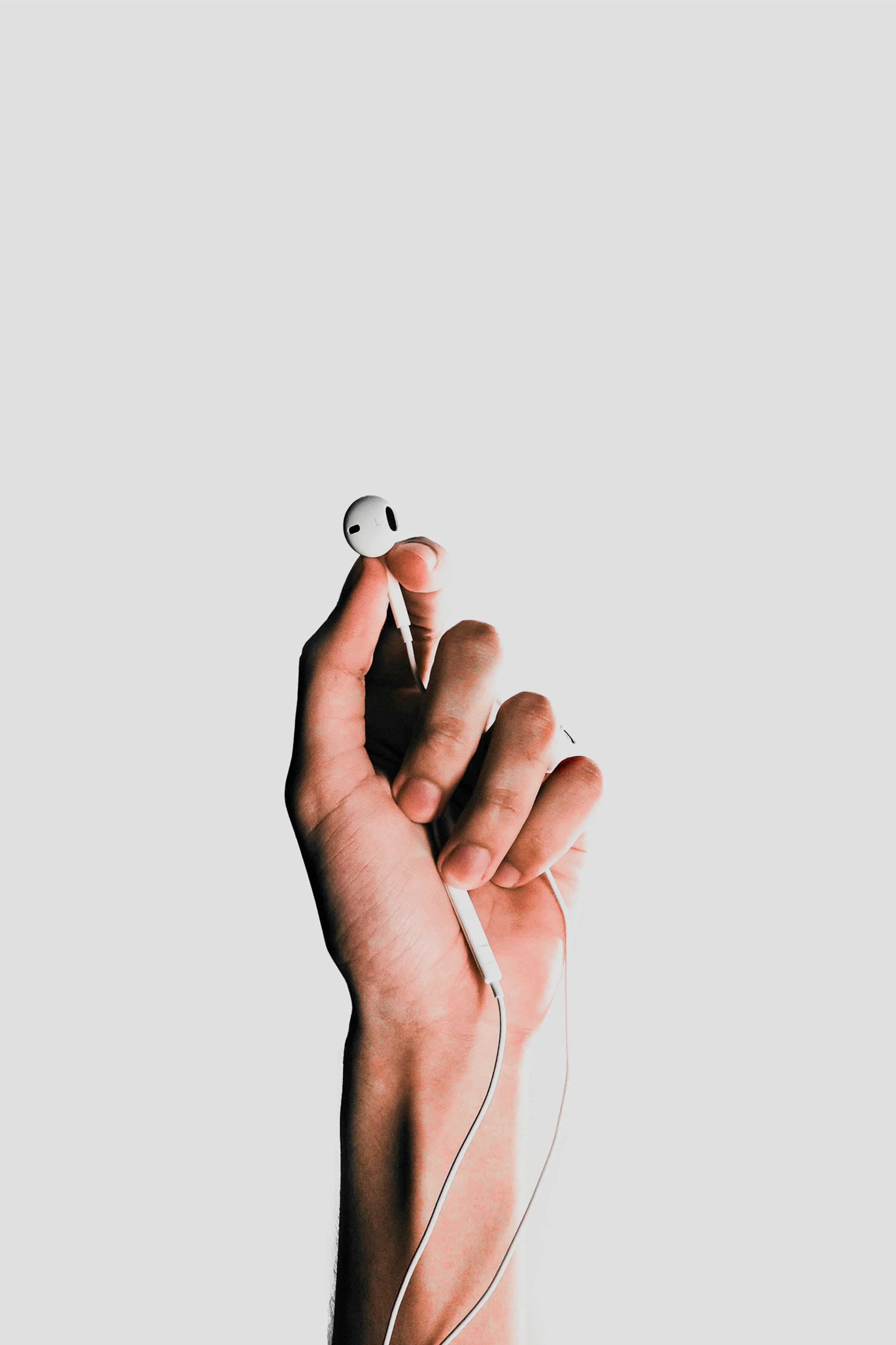 A hand holding earphones